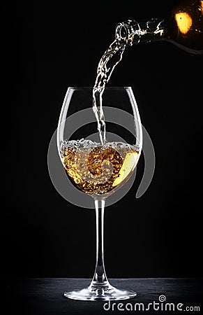 Pouring white wine into a glass Stock Photo