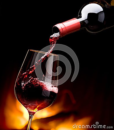 Pouring wine by the fireplace Stock Photo