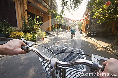 POV bicycle riding of tourist in ancient city Hoi An Stock Photo