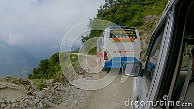 POV: Driving behind a tourist bus and along a bumpy dirt road in rural Nepal. Editorial Stock Photo