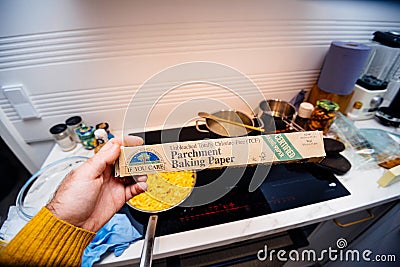 Pov male hand holding against kitchen background new Parchment Baking paper Editorial Stock Photo