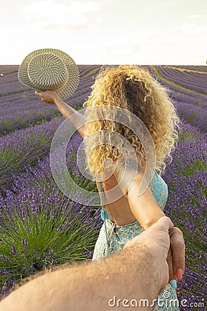 Pov of man holding woman hands with beautiful lavender field in background. Happy couple in travel lifestyle enjoying amazing Stock Photo