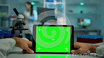 Pov shot of microbiologist holding tablet with green chroma key Stock Photo