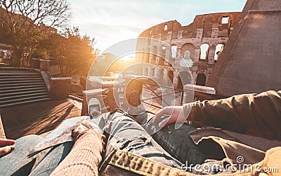 Pov view of couple enjoying sunset in front of colosseum - Young people having fun traveling europe - Trip, love and relationship Stock Photo