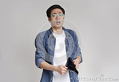 Poverty and absence of money. Worry asian guy showing empty wallet Stock Photo