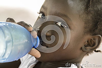 Poverty Symbol: African Black Girl Drinking Heathy Fresh Water. Stock Photo