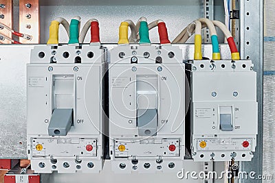 Power circuit breakers are arranged in a row in an electric Cabinet. Stock Photo