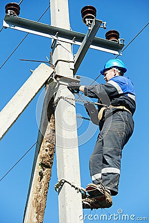 Power electrician lineman at work on pole Stock Photo