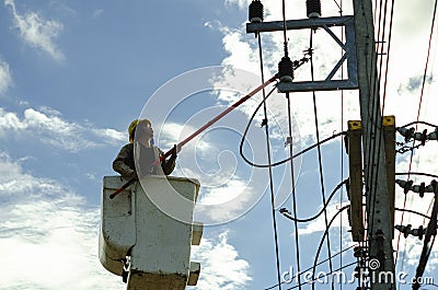 The power lineman in cable car use clamp stick to closing a transformer on energized high-voltage electric power lines. blue sky Editorial Stock Photo