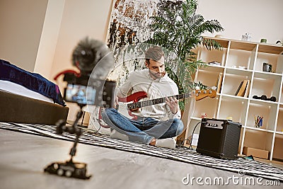 Power of music. Close up of digital camera screen with male music blogger playing electric guitar and recording new Stock Photo