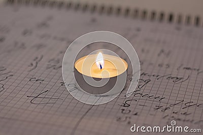 Power outage. Home school assignments are about candles. Elementary school math problems and a candle. Stock Photo