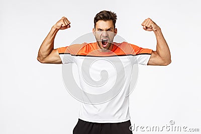 Power, sport and fitness concept. Handsome strong and powerful aggressive man brag perfect shape, shouting, encourage Stock Photo