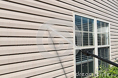 Power washing. House wall siding cleaning with high pressure water jet. Stock Photo