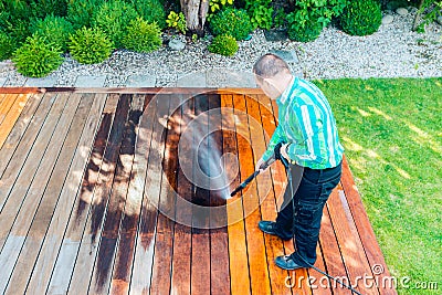 Power washing - man cleaning terrace with a power washer - high water pressure cleaner on terrace surface Stock Photo