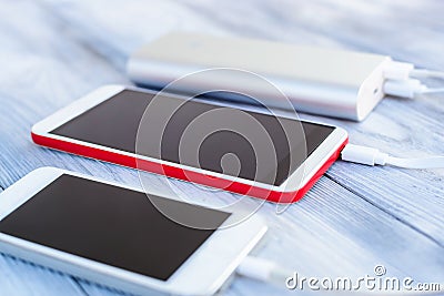 Powerbank charging white and red smartphone Stock Photo