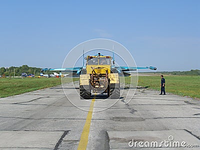 Powerful Russian military jet fighter plane on the runway of the SU-34 tractor carries engine Editorial Stock Photo