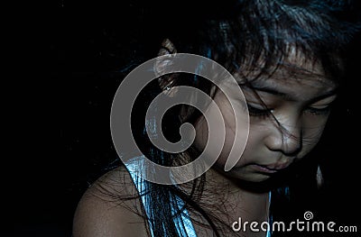 Powerful shot of a sad asian child. Female asian child sad dark scene Stock Photo