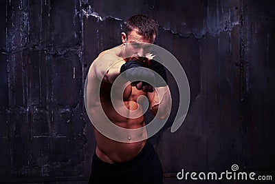 Powerful sportsman practicing a jab in black boxing gloves over Stock Photo