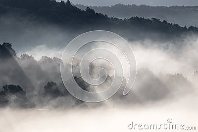 Powerful sun rays cutting through the fog and projecting shadows Stock Photo