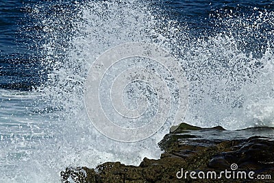 Powerful wave crashing on a rock in the ocean Stock Photo