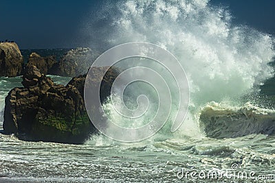 Powerful wave crashing on the rocks at a beach in Malibu Stock Photo