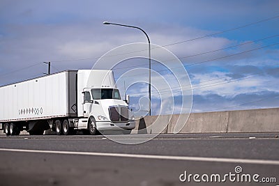 Powerful white day cab big rig semi truck with roof spoiler tran Stock Photo