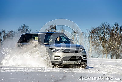 Powerful 4x4 offroader car running on snow field Stock Photo