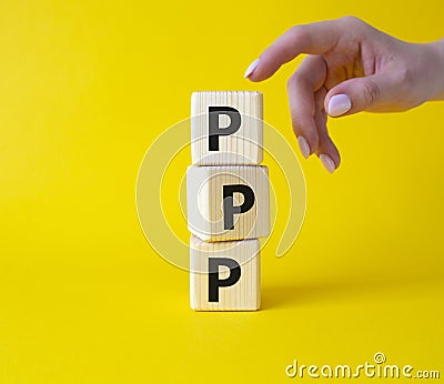 PPP private public partnership symbol. Wooden cubes with words PPP. Businessman hand. Beautiful yellow background. Business and Stock Photo