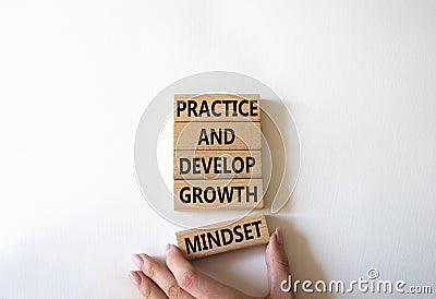 Practice and Develop growth mindset symbol. Wooden blocks with words Practice and Develop growth mindset. Businessman hand. Stock Photo