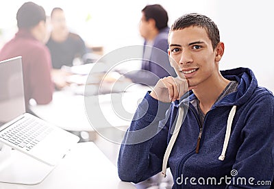 We practice excellence in everything we do. Portrait of a confident young man working on his laptop in an office. Stock Photo