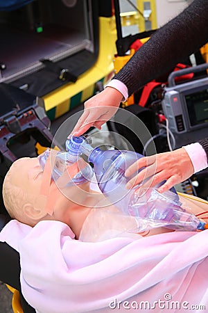 Practicing to use an oxygen mask on training doll Stock Photo