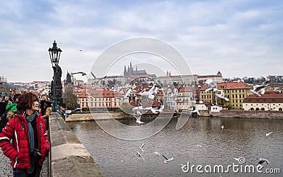 Prague, Bohemia / Czech Republic - November 2017: tourists walking on the Charles bridge with view on Prague castle and Vltava riv Editorial Stock Photo