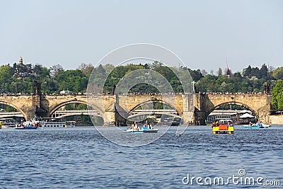 Tourist sailing on pedal boats on Vltava river near Charles bridge in Prague, Czech Republic Editorial Stock Photo