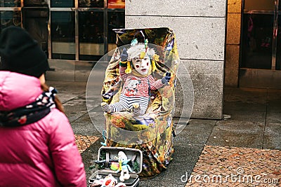 Prague, Czech Republic, December 24, 2016 - A funny clown an adult is disguised as a child in a stroller . Entertainment Editorial Stock Photo