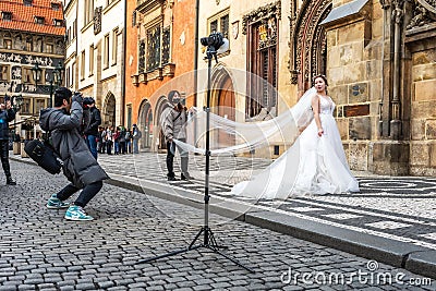 Prague, Czech Republic -January 20, 2020: Chinese photographer takes pictures of a wedding couple Editorial Stock Photo