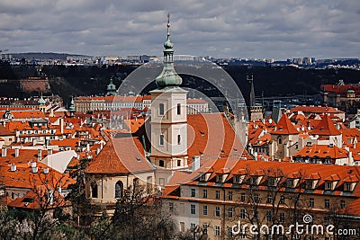 Prague, Czech Republic, 26 March 2023: Panorama of old town from Petrin Hill, Red roofs, Cloudy spring day, bell tower of Church Editorial Stock Photo