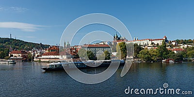 A large tourist boat at the pier on the Vltava River. View of Prague Editorial Stock Photo