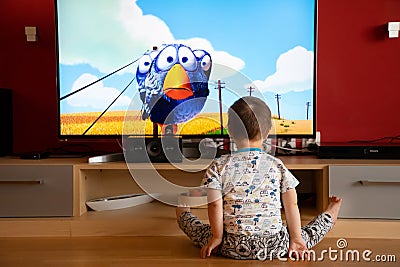 Prague, Czech Republic -18.03.2019: Small boy with Down syndrome watching cartoon Editorial Stock Photo