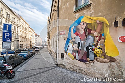 Graffiti by Chemis artist depicts a little girl hiding a European fairy tale character under a blanket from Ukrainian flag Editorial Stock Photo