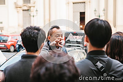 Prague, September 21, 2017: Asian guide emotionally tells Asian tourists about the sights of the city and interesting Editorial Stock Photo