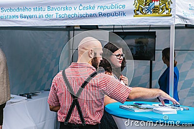 Prague, September 23, 2017: Celebrating the traditional German beer festival called Oktoberfest. The man takes booklets Editorial Stock Photo