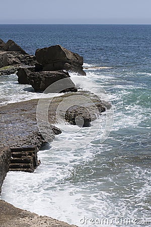 Praia da Azarujinha, beach in Estoril, portugal. Black stone coast with steps to ocean Stock Photo