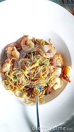 Prawn Chow & noodles in a white plate & spoon . Stock Photo