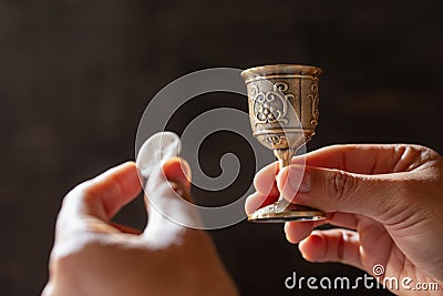 Pray with holding loaf and little cup of the wine Stock Photo