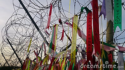 Prayer ribbons attached to a barbed wire fence Editorial Stock Photo