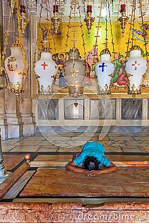 Prayer at Stone of Anointing at the entrance to the Church of the Holy Sepulchre in Jerusalem. Editorial Stock Photo