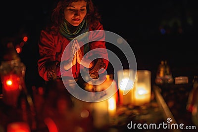 prayer woman. Candles in the cemetery. 1st November. Feast of All Saints. Hallowmas. All Souls& x27; Day. Stock Photo