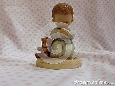 Praying Child With Teddy Figurine Stock Photo