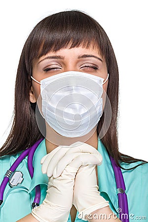 Praying female medical doctor with mask isolated Stock Photo