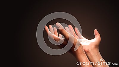 Praying hands with faith in religion and belief in God on dark background. Power of hope or love and devotion Stock Photo